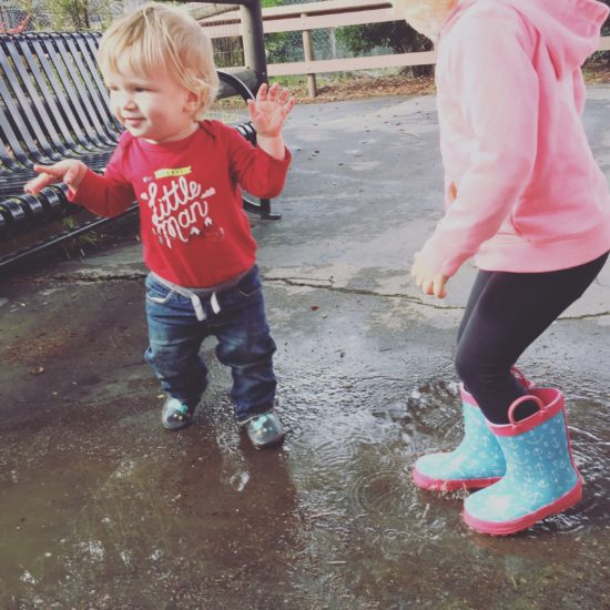 Two kids jumping in rain puddles - by Tonya Strickland