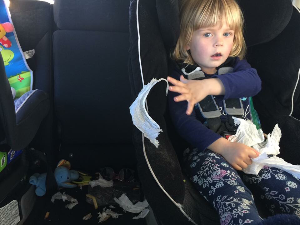 Toddler making a mess in the backseat