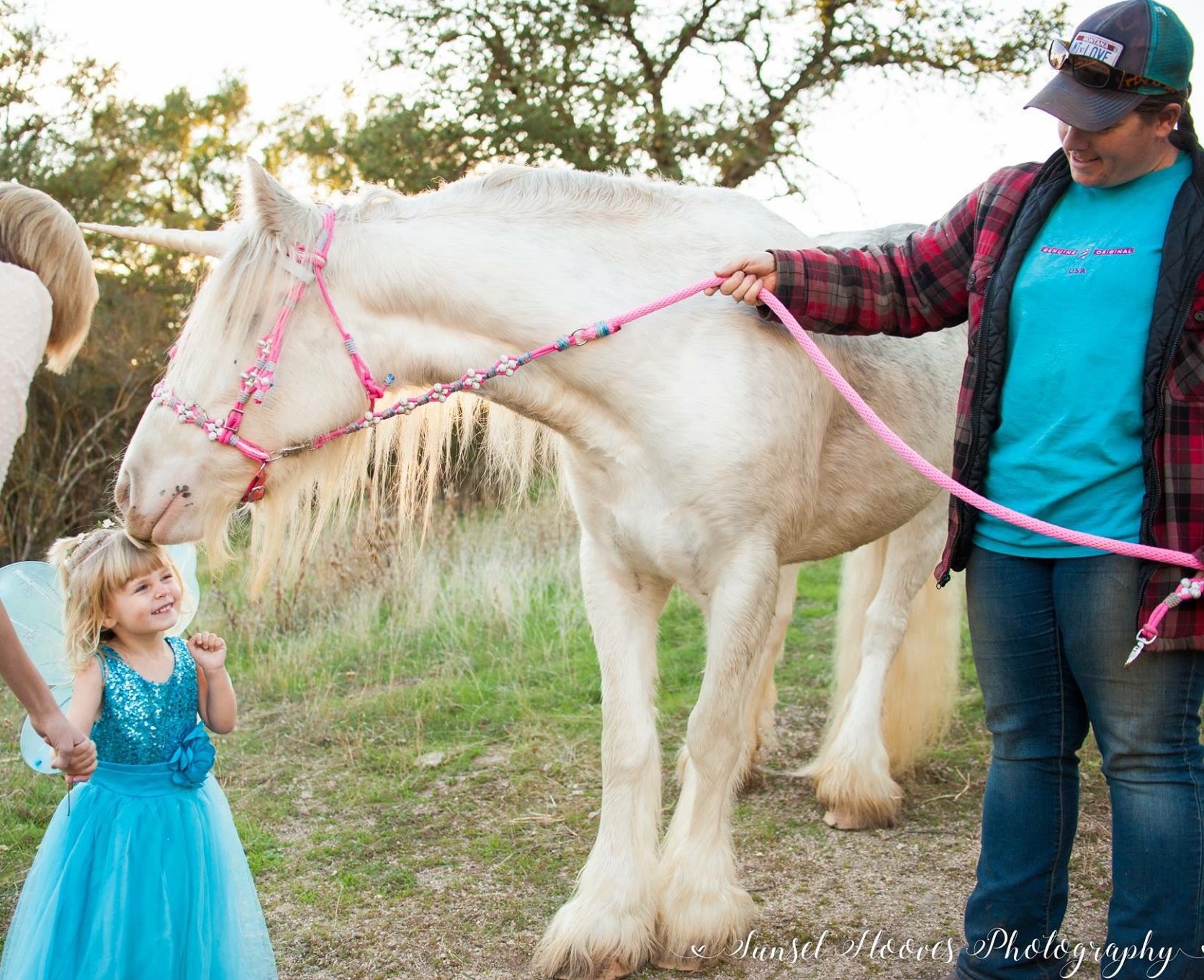 Magical unicorn nuzzles toddler dressed as a fairy princess in unicorn photoshoot in Creston, California.