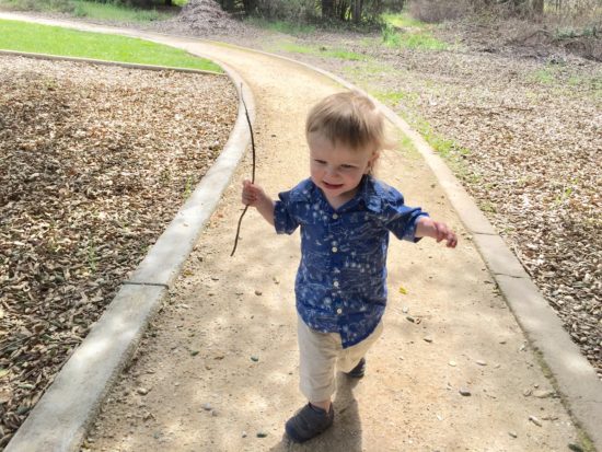 Baby loves his sticks at Apple Valley Park in Atascadero California from the blog Two In Tow & On The Go.