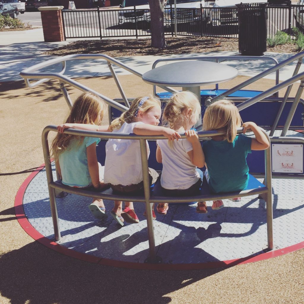 Friends on the New and modern merry-go-round at the Paso Robles Downtown City Park Playground