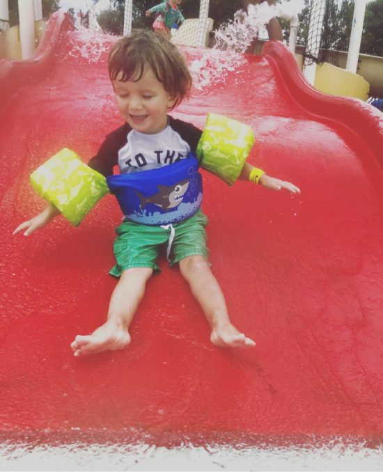 Boy on a red waterslide.