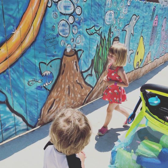 Two kids look at a waterpark mural