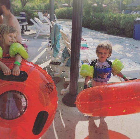 Two kids with intertubes at a waterpark.