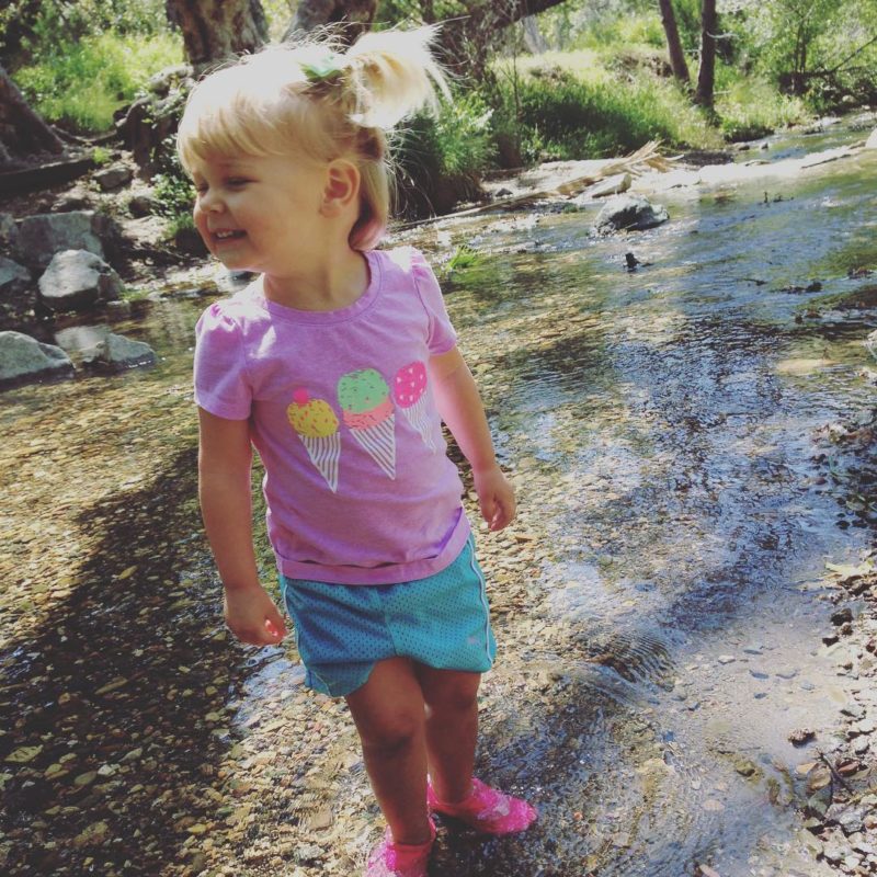 Little girl splashing in a creek