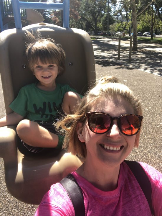 mom and son on double playground swing