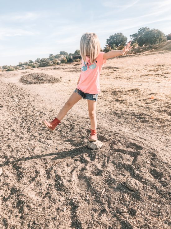 Girl standing on rock with Bobux Paddington Red Boot_3