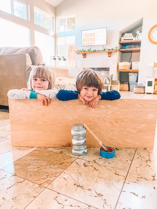 two kids getting ready to paint wooden sign