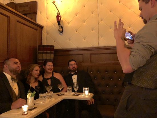 lavishly dressed group in dimly lit bar