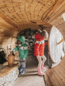 boy and girl inside a hobbit house in front of a fireplace