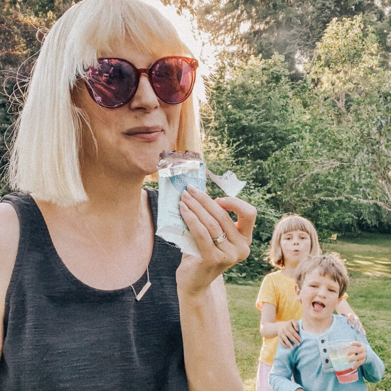 mom trying to eat chocolate bar with kids in background