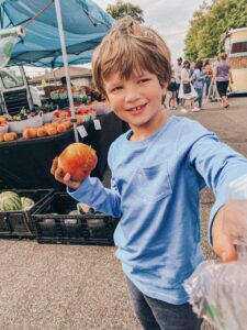 boy in blue shirt holding peach