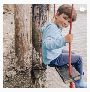 boy on swing above water