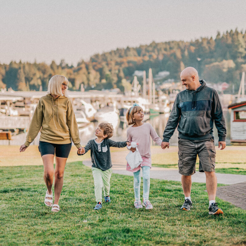 family on grass at harbor with boats