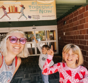 Kids in front of yellow library banner